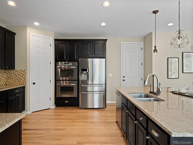 41 Garner Ln, Erie, CO 80516 - kitchen with stainless steel appliances, a sink, light wood-type flooring, recessed lighting, and pendant lighting