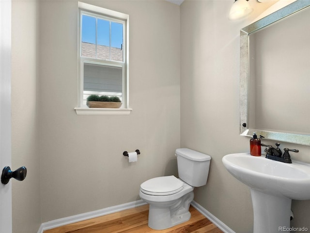 41 Garner Ln, Erie, CO 80516 - half bath with wood finished floors, toilet, baseboards, and a sink