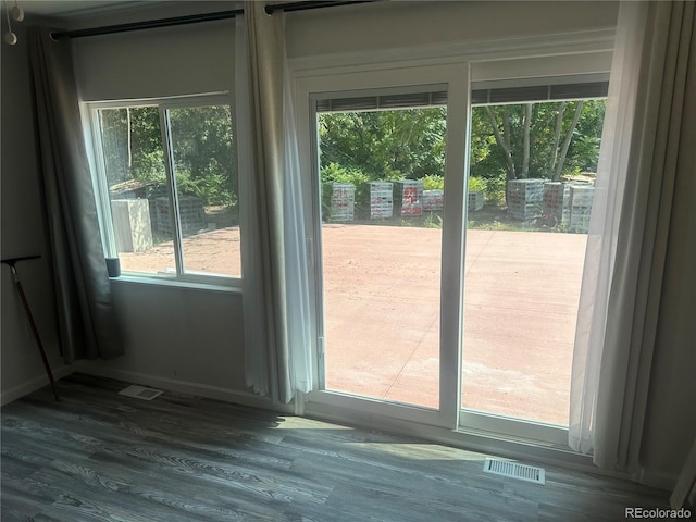 doorway with wood finished floors and visible vents