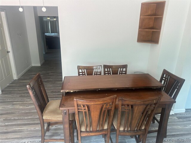 dining space featuring wood finished floors and baseboards