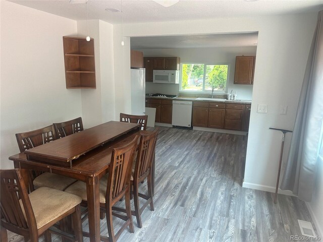 dining area featuring light wood-style flooring and baseboards