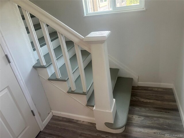 stairway with baseboards and wood finished floors