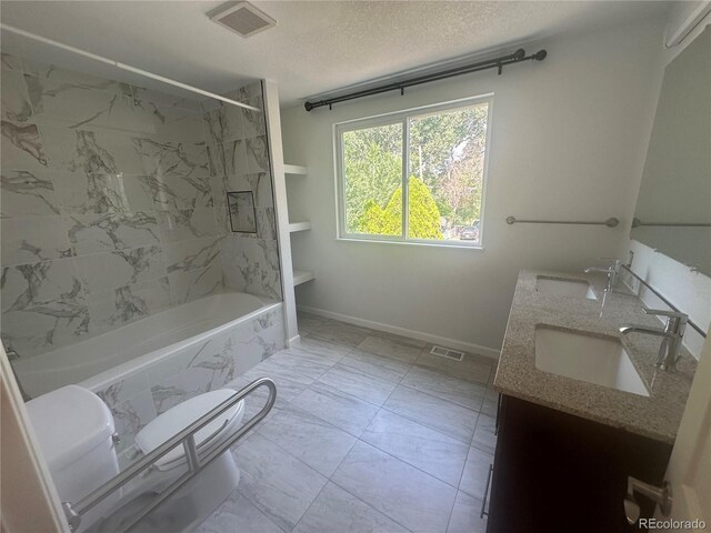 full bathroom featuring a textured ceiling, visible vents, marble finish floor, and a sink