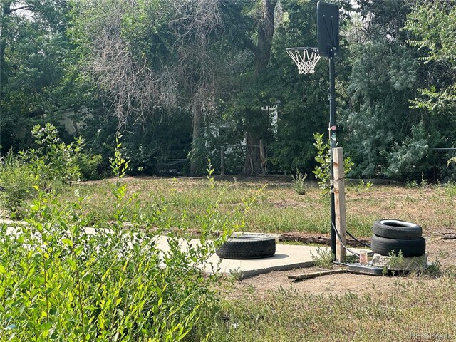 view of yard featuring a view of trees and an outdoor fire pit