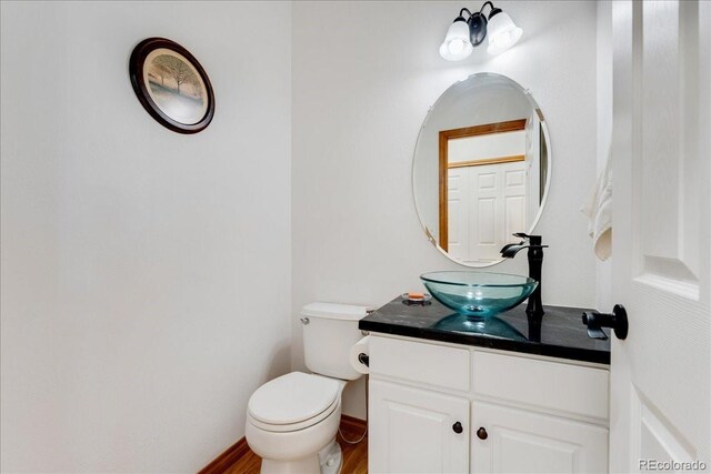 11705 W Stanford Ln, Morrison, CO 80465 - bathroom with vanity, toilet, wood finished floors, and baseboards