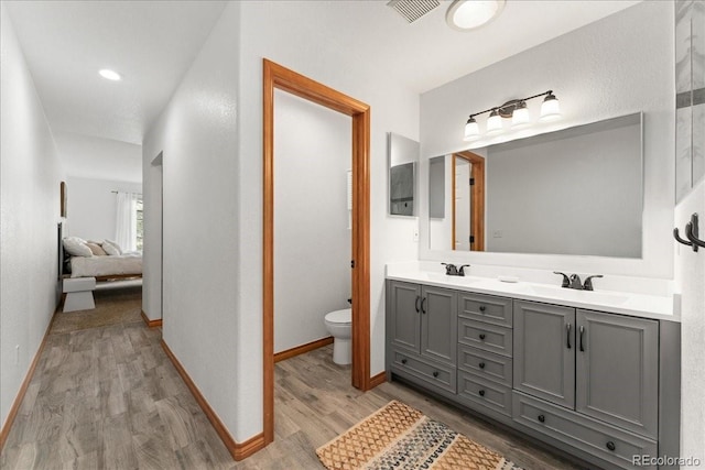 11705 W Stanford Ln, Morrison, CO 80465 - ensuite bathroom with wood finished floors, double vanity, toilet, and baseboards
