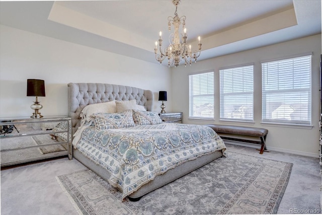 bedroom featuring a raised ceiling, carpet flooring, and an inviting chandelier