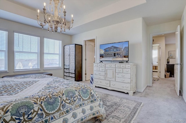 carpeted bedroom with an inviting chandelier and a tray ceiling