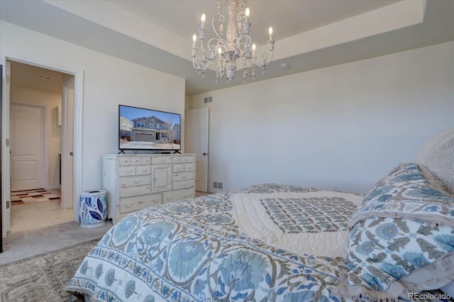 carpeted bedroom featuring a notable chandelier and a tray ceiling