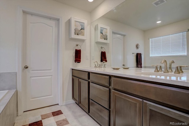 bathroom featuring a relaxing tiled tub and vanity