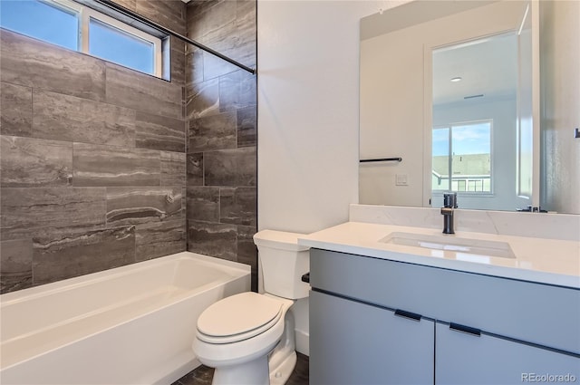 full bathroom featuring tiled shower / bath, vanity, and toilet