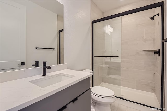 bathroom with vanity, toilet, and a shower with door