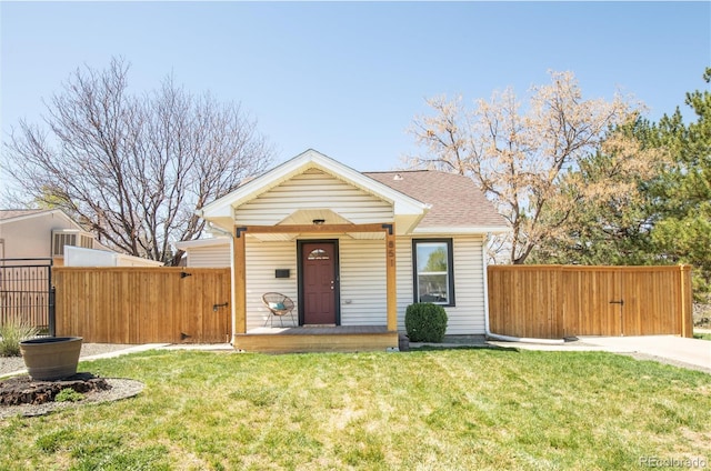 view of front of property featuring a porch, fence, a front yard, and a gate
