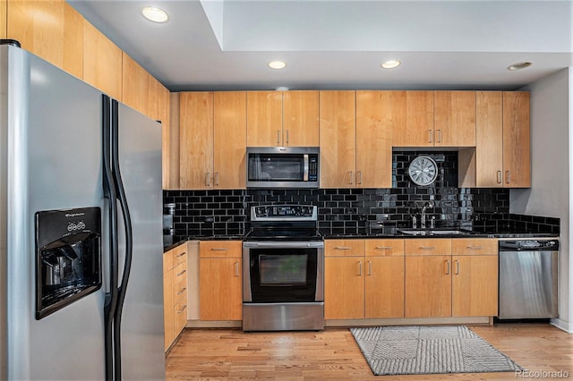 kitchen with stainless steel appliances, dark countertops, recessed lighting, and a sink