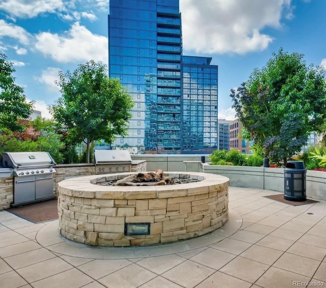 view of patio / terrace with an outdoor kitchen, a fire pit, and a grill