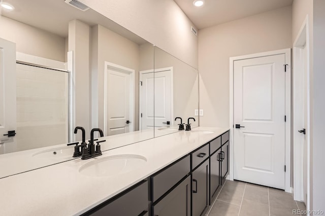 bathroom with tile patterned floors, vanity, and a shower with door