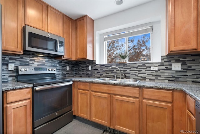 kitchen with stainless steel appliances, tasteful backsplash, light stone countertops, and sink