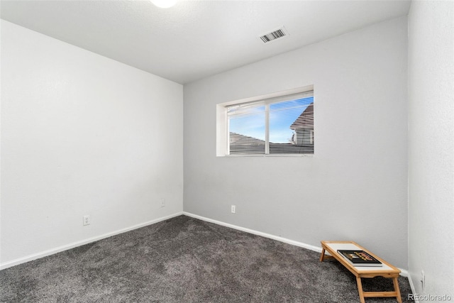 unfurnished room with dark carpet