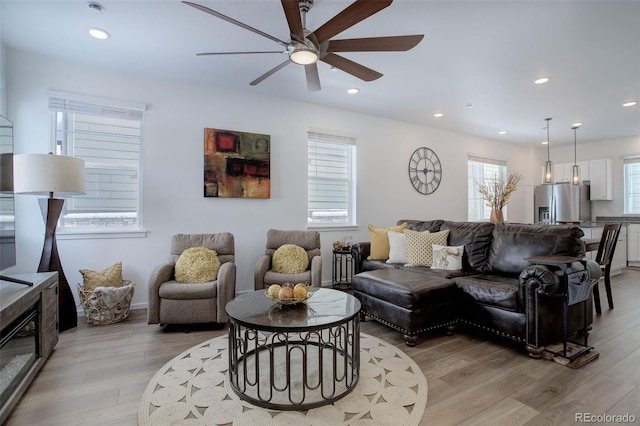 living room with ceiling fan, light hardwood / wood-style flooring, and a healthy amount of sunlight