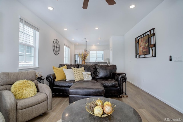 living room with ceiling fan, light wood finished floors, recessed lighting, and baseboards