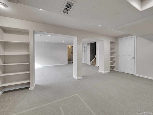 finished basement featuring stairs, carpet flooring, visible vents, and baseboards