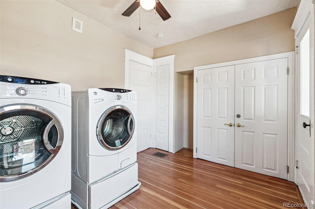 laundry room with laundry area, visible vents, washer and clothes dryer, ceiling fan, and light wood-type flooring