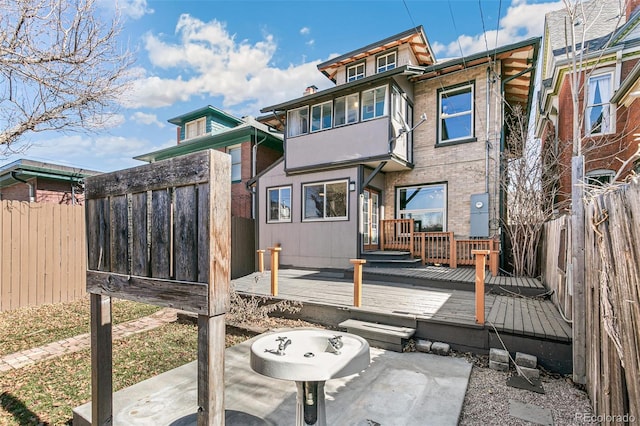 rear view of property featuring a fenced backyard and a wooden deck