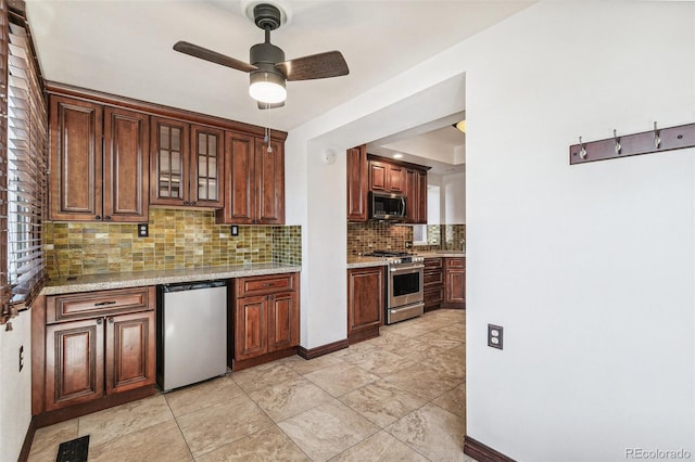 kitchen featuring tasteful backsplash, visible vents, a ceiling fan, glass insert cabinets, and appliances with stainless steel finishes