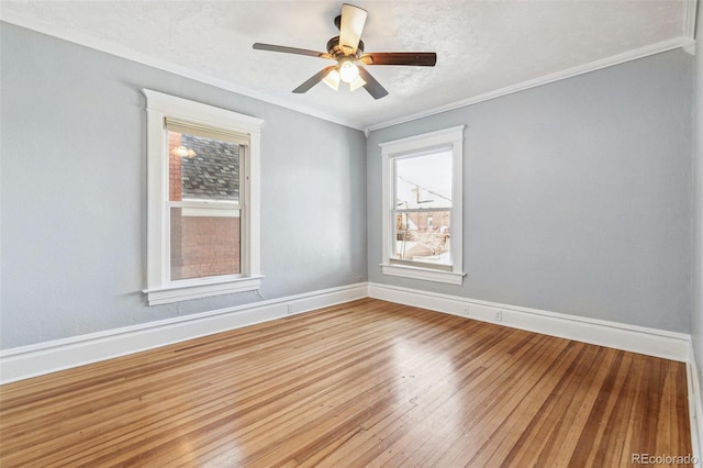 spare room with a textured ceiling, a ceiling fan, baseboards, ornamental molding, and hardwood / wood-style floors