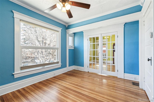 unfurnished room with baseboards, visible vents, ornamental molding, and wood finished floors