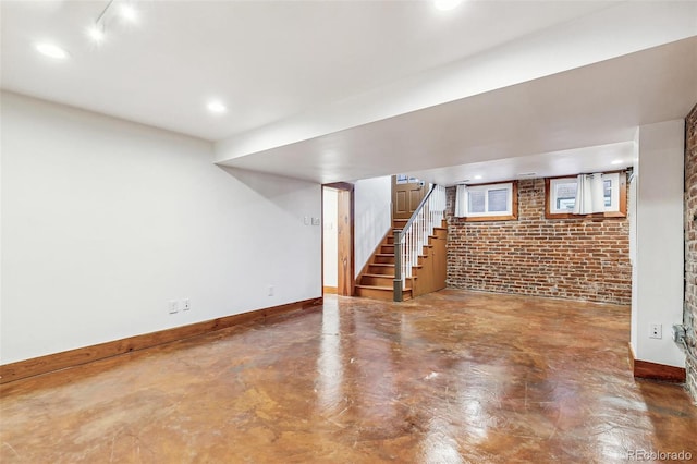 finished basement with recessed lighting, brick wall, stairway, and baseboards