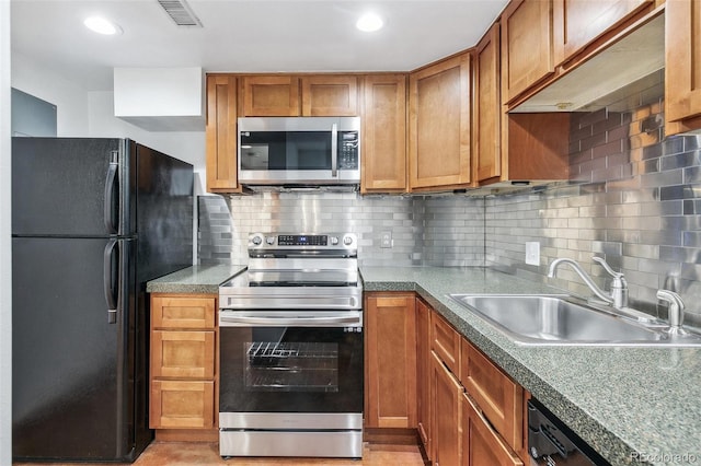 kitchen featuring brown cabinets, stainless steel appliances, tasteful backsplash, visible vents, and a sink