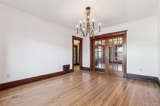 unfurnished dining area featuring french doors, baseboards, a notable chandelier, ornamental molding, and light wood-style flooring