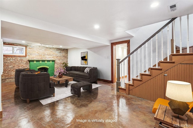living area with concrete flooring, a fireplace, brick wall, visible vents, and stairway