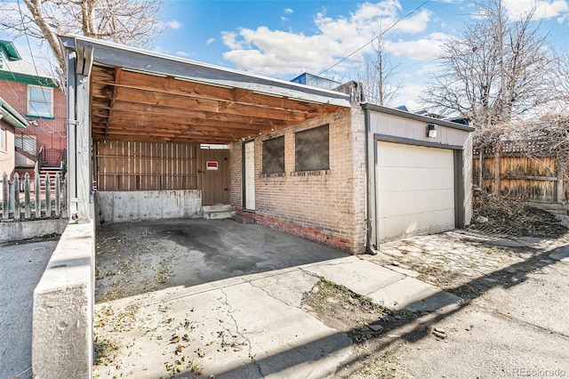 view of front facade featuring brick siding, fence, and driveway
