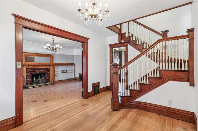 1451 N Gilpin St, Denver, CO 80218 - stairs featuring a chandelier, wood-type flooring, and a brick fireplace