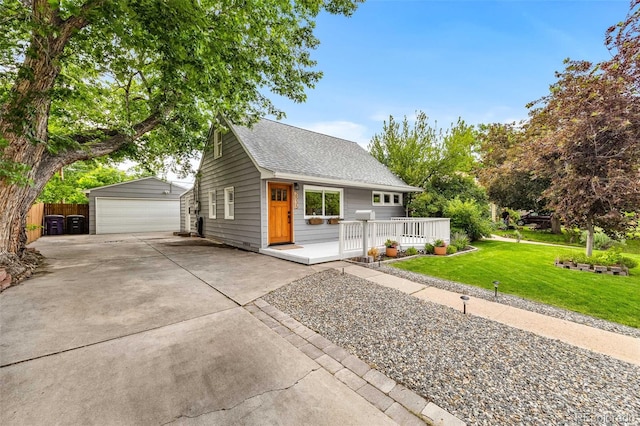 2535 S Julian St, Denver, CO 80219 - view of front of property with an outbuilding, a garage, a front yard, a shingled roof, and covered porch