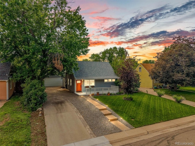 2535 S Julian St, Denver, CO 80219 - view of front facade with covered porch, an outdoor structure, a yard, and roof with shingles