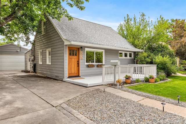 2535 S Julian St, Denver, CO 80219 - view of front facade featuring an outdoor structure, roof with shingles, a detached garage, driveway, and a front lawn