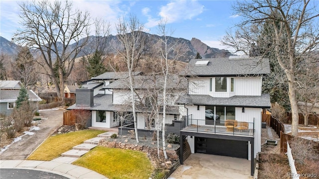 view of front of home with a mountain view, a garage, a balcony, and a front yard