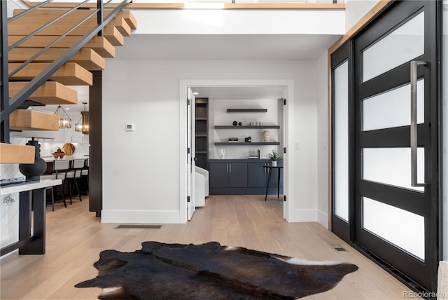 entryway featuring light wood-type flooring and an inviting chandelier