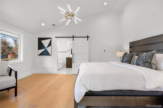 bedroom featuring a barn door, an inviting chandelier, connected bathroom, and vaulted ceiling