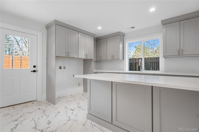 kitchen with gray cabinets, a healthy amount of sunlight, and sink