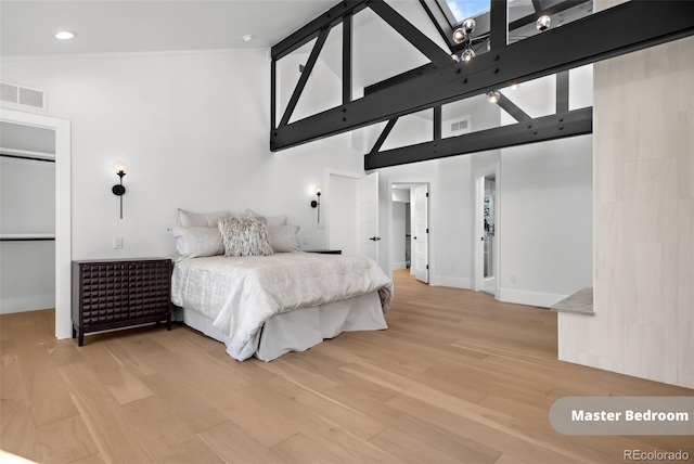 bedroom with wood-type flooring and high vaulted ceiling