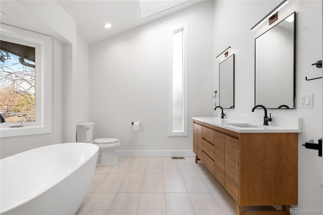 bathroom with vanity, toilet, and a tub to relax in