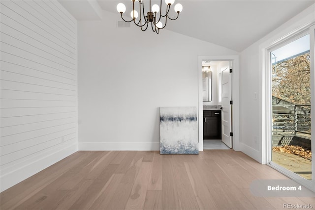 interior space featuring vaulted ceiling, light hardwood / wood-style flooring, and a chandelier