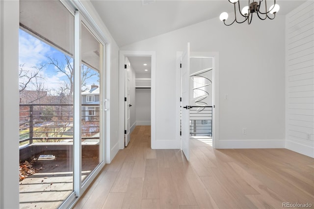 interior space with vaulted ceiling, light hardwood / wood-style flooring, and an inviting chandelier