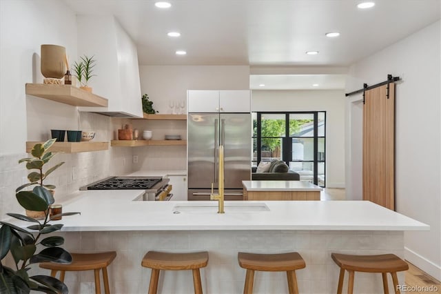 2844 Quitman St, Denver, CO 80212 - kitchen with open shelves, high end refrigerator, a peninsula, a kitchen breakfast bar, and light countertops