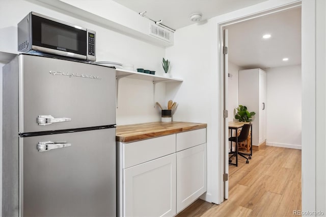 2844 Quitman St, Denver, CO 80212 - kitchen featuring appliances with stainless steel finishes, butcher block countertops, light wood finished floors, white cabinetry, and recessed lighting