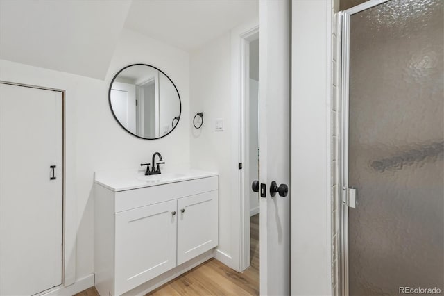 2844 Quitman St, Denver, CO 80212 - bathroom with wood finished floors, a shower stall, vanity, and baseboards
